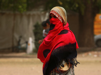 A woman uses a shawl to cover herself during a dust storm, at India Gate on March 30, 2021 in New Delhi, India. The India Meteorological Dep...
