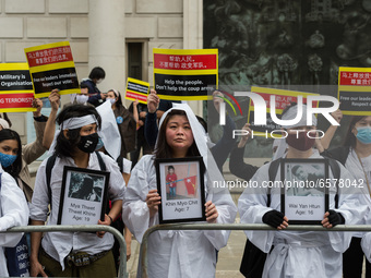 LONDON, UNITED KINGDOM - MARCH 31, 2021: Protesters wearing traditional white Chinese funeral attire demonstrate outside the Chinese Embassy...