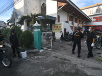 Armed police stand guard around the church in Palu, Central Sulawesi, Indonesia, Thursday (1/4/2021). The government has tightened and incre...