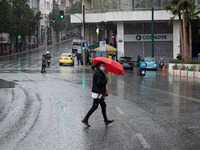 People seen wearing protected mask and holding umbrellas during a rainy day in Athens, Greece on April 1, 2021.  (