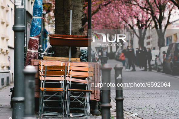tables and chairs are seen stacking on the street as early cherry blossoms are seen in historical district in Bonn, Germany on April 04, 202...