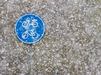 Close up of bike and scooter sigh with snow. Snowfall in the Netherlands makes the first 