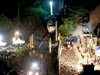 Police officers remove belongings from and conduct investigations at a scene where a train carrying 490 people has been derailed, in Hualien...