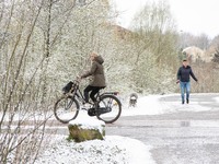 People cycling during the snow. The Netherlands wakes up snow covered after an intense morning snowfall, a bizzar event for April. The secon...