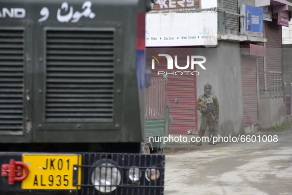An Indian paramilitary trooper remain alert in a residential area where militants were believed to be trapped during cordon in Gulab Bagh ar...