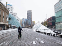 Melting snow in Eindhoven city center in 18 Septemberplein square with a man cycling a bike. The third day of the unusual April snowfall in...