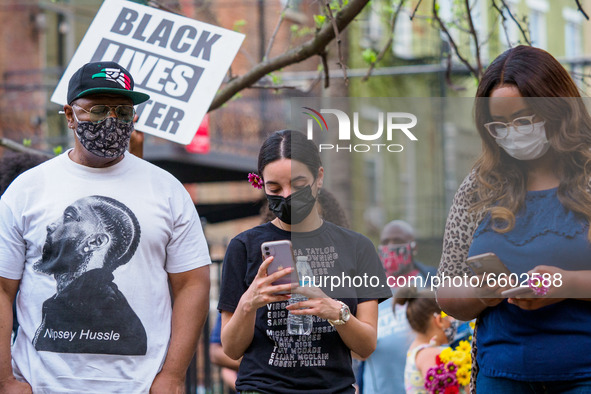People look at their cell phones to update their social media as people gather at Washington Park in memorial and then march to where Timoth...