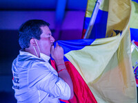 Presidential Candidate of Union por la Esperanza Andres Arauz kiss an Ecuadoran flag while running on stage during the closing event of his...