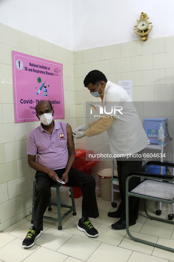 A man receives a dose of COVISHIELD coronavirus disease (COVID-19) vaccine manufactured by Serum Institute of India, at a government hospita...