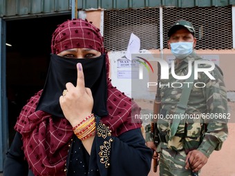 An Muslim woman  Voter shows her finger after casting her vote outside a polling station during Phase 4 of West Bengal's legislative electio...