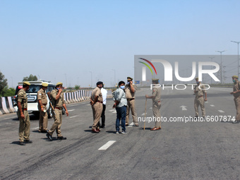Uttar Pradesh Police personnel stand guard during a 24-hour blockade of KMP Expressway (Kundli–Manesar–Palwal) by farmers as a part of their...