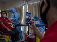 A medical officer injects the COVID-19 vaccine into a tourism sector worker in Palu, Central Sulawesi Province, Indonesia on April 10, 2021....