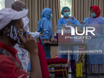Medical officers prepare an injection of the COVID-19 vaccine for a tourism sector worker in Palu, Central Sulawesi Province, Indonesia on A...