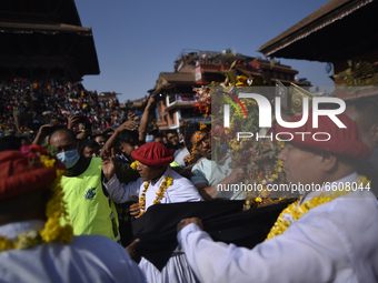 Nepalese priests carrying God Bhairab towards the chariot to commence the first day of the Biska or Bisket Jatra at Taumadi, Bhaktapur, Nepa...