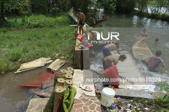 Resident wash mosque prayer mats at a river as they prepare for Ramadan on April 11, 2021 in Semarang Regency, Indonesia. This tradition has...