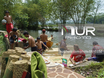 Resident wash mosque prayer mats at a river as they prepare for Ramadan on April 11, 2021 in Semarang Regency, Indonesia. This tradition has...
