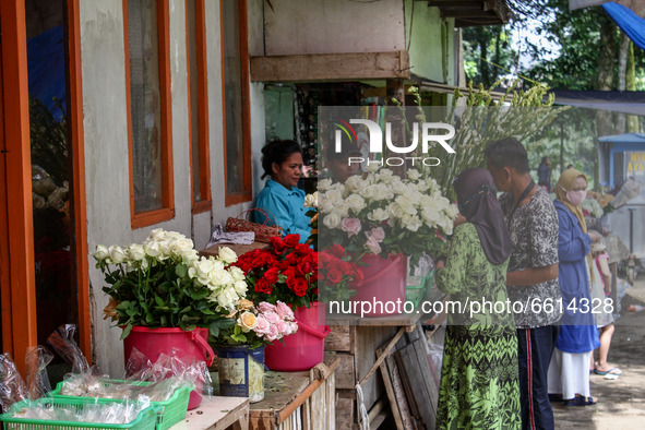 A woman sells flowers waits for a customers at Cibarunai Tomb on 12, April, 2021 in Bandung, Indonesia. Before the month of Ramadan begins,...