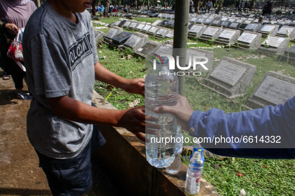A woman fill the water bottle during a Nyadran ritual on 12, April, 2021 in Bandung, Indonesia. Before the month of Ramadan begins, Indonesi...