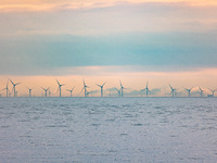 Off-shore wind park of windmills generating green renewable electric energy 20 kilometers away from the Dutch coast between the Netherlands...