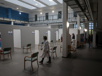 A doctor walking through the hall of an empty vaccination point in Pisa, Italy, on April 12, 2021. The campaign for vaccination against Covi...