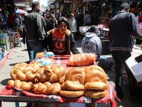 A Palestinian hawker wheels his wares in the market during the first day of the holy fasting month of Ramadan, in Gaza City, Tuesday, April...