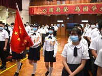 A flag raising team from the school marches in with a Flag of China, during a flag raising ceremony on the National Security Education Day,...