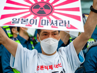 A protester holds a Rising Sun flags that say the Japanese Government Should Drink Fukushima Radioactive Contaminated Water during a protest...