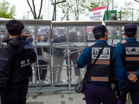 Police block the area with temporary walls to prevent protesters from approaching the Japanese Embassy in Seoul during a protest against the...