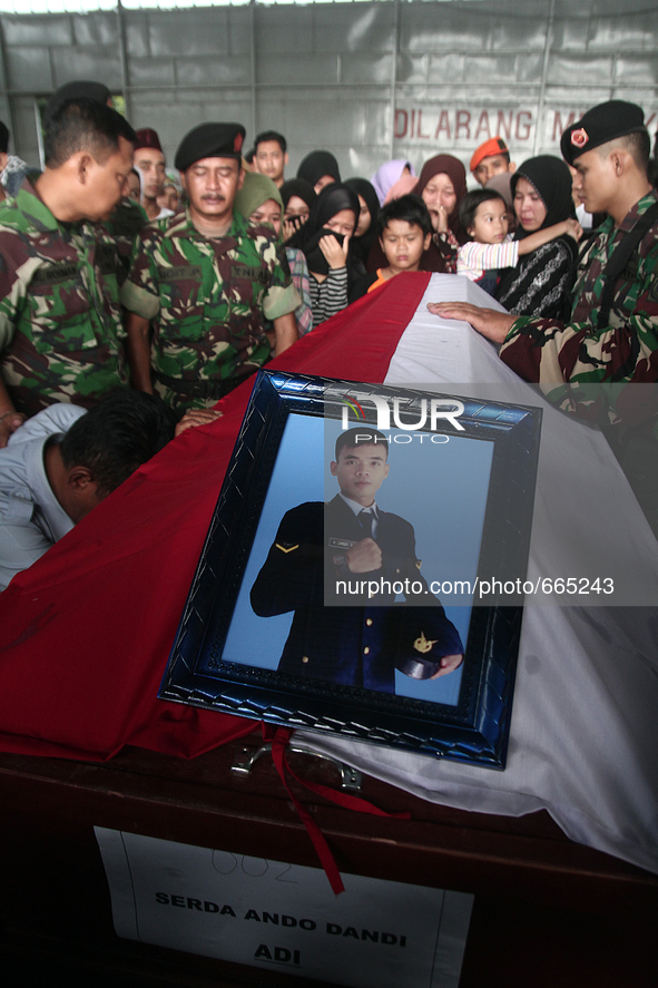 Relatives grieve beside the coffin of the body bodies of military personnel, one of the victims of the collapse of the C-130 military aircra...