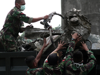 Indonesian military personnel load the aircraft wreckage Indonesia C-130 Hercules into the back of a truck, a day after the crash in Medan,...