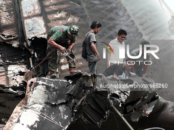 Indonesian military personnel inspect aircraft wreckage bodies Indonesian C-130 Hercules day after the crash in Medan, North Sumatra, Indone...