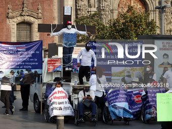 Persons take part during a protest, outside the National Palace, due were victims of fraud by the  Banco Ahorro Famsa, on April 26, 2021 in...