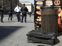 Police officers stand near a suitcase after the New York Police Department Bomb Squad and ATF agents were called about a suspicious package...