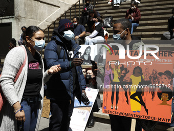 People holding up signs rally on the steps of Federal Hall to raise attention about the women inmates at Riker’s Island prison on April 26,...