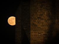 The Pink Super Moon is seen as it passes a church in Warsaw, Poland on April 27, 2021. The Pink Super Moon is second to last super moons in...