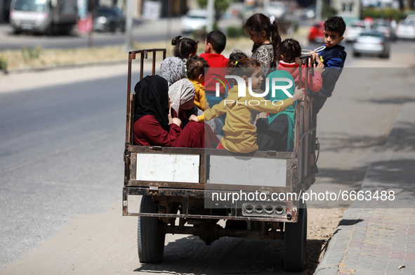 A Palestinian family rides in the back of a tuktuk in a street in Gaza City, on April 28, 2021.  