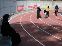  A Palestinian trainer teaches a woman how to ride a bicycle at the Yarmouk Stadium in Gaza city on April 28, 2021.The 
