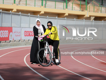  A Palestinian trainer teaches a woman how to ride a bicycle at the Yarmouk Stadium in Gaza city on April 28, 2021.The 