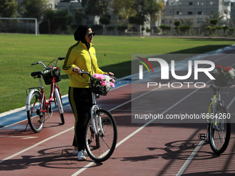  A Palestinian woman rides bicycle at the Yarmouk Stadium in Gaza city on April 28, 2021. The 