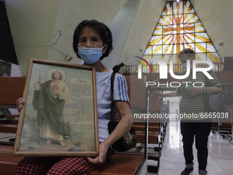 A woman holds a picture with the image of St. Jude Thaddeus inside a parish with the same name located in Mexico City, Mexico, on April 28,...