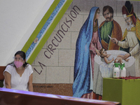 A volunteer from the Parish of St. Jude Thaddeus the Apostle located in Mexico City, Mexico, on April 28, 2021 in front of a mural of the Go...