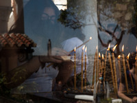 Worshippers lined up to light candles in the yard of Church of Agioi Anargyroi Holy Metohi Panagiou Tafou in Plaka, Athens, Greece, on April...