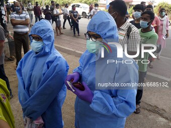 People taking Covid-19 coronavirus vaccine and other are seen in the queue as they wait for their turn for vaccination in the eastern Indian...