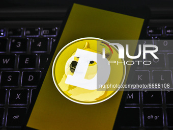 Dogecoin logo is displayed on a mobile phone screen photographed for illustration photo. Gliwice, Poland on May 6, 2021. Dogecoin, the meme...