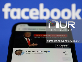 Donald Trump's Facebook account is seen displayed on a phone screen with Facebook logo in the background in this illustration photo taken in...