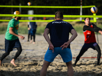 A group of friends, consisting of Brazilians, Russians, Lithuanians, French and Italians, playing beach volleyball at Poolbeg Beach, Dublin,...