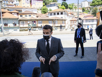 French President Emmanuel Macron wears a protective mask as he talks to journalists while arriving in Alfandega building to participate of t...