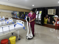 A health worker gives demo of a machine where a covid patient can talk to a doctor through this machine in a temporary converted covid care...