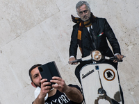 A man takes selfie in front of a mural by artist Harry Greb depicting the new coach of the AS Roma football team, Jose Mourinho riding a mot...