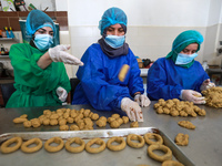  Palestinian women prepare traditional date-filled cookies in preparation for the Eid al-Fitr holiday in the northern Gaza Strip, on  May 8,...